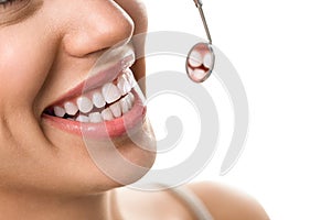 Close-up of smile patient with healthy tooth with dental mirror