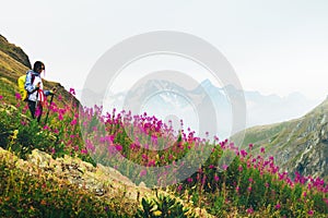 Close up smiley Caucasian woman hiker with hiking pols hiker in majestic mountains in blooming spring nature.Solo hiking healthy photo