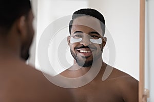 Close up smiling African American man with hydrogel eye patches