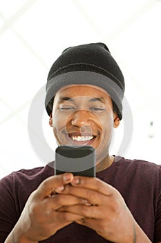 Close up smiling african american man looking at mobile phone