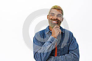Close up of smiling african american man, looking thoughtful and pleased, nod in approval while thinking, standing over