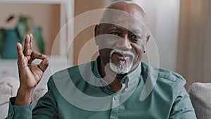 Close up smiling african american mature man portrait pleased pensioner male sitting in apartment happy wrinkled face