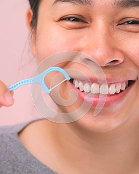 Close-up of smiling asian woman and cleaning for perfect smile. Healthy white teeth by flossing, oral health and dental care