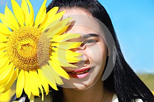 Close-up of a smiling asian woman face with a sunflower