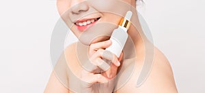 Close up of smiling Asian woman hand holding cosmetic bottle and products template for logo, body lotion.