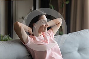 Close up smiling beautiful Arabian woman relaxing on couch