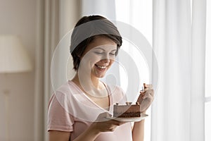 Close up smiling beautiful woman eating cake, enjoying dessert