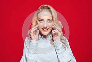 Close-up smiling beautiful woman, isolated on red background. Head and shoulders. Happy cute girl, front view