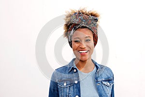 Close up smiling black woman wearing headscarf standing against white background