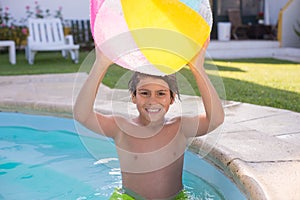 Close-up of smiling boy standing in swimming pool