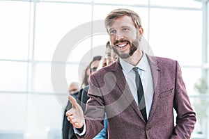 Close up. smiling businessman holding out his hand for a handshake