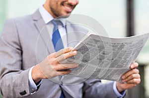 Close up of smiling businessman reading newspaper