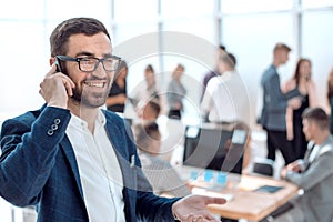 Close up. smiling businessman talking on his smartphone