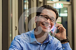 Close up of smiling businessman using modern smart phone, Young happy man working at his office and holding cellphone