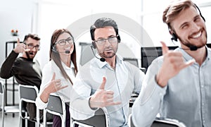 Close up.smiling call center staff showing thumb up