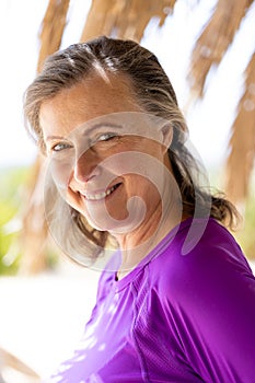 Close-up of smiling caucasian beautiful senior woman looking at camera at tourist resort