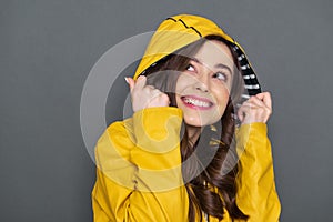Close up of smiling Caucasian girl dressed in yellow raincoat in studio