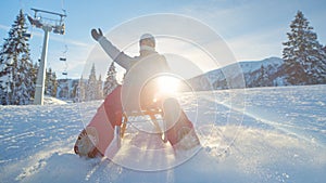 CLOSE UP: Smiling Caucasian woman sleds down the slopes of a closed ski resort.