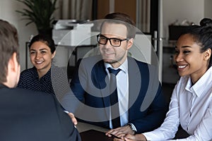 Close up smiling confident businessman shaking partner hand at meeting