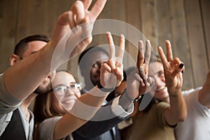 Close up of smiling diverse people showing peace sign