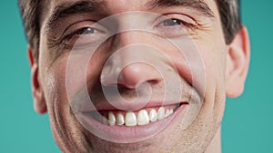 Close-up smiling face of man on blue.Perfect healthy teeth.Fun and joy lifestyle