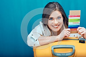 Close up smiling face portrait of young woman holding passport w