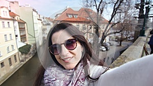 Close-up smiling female tourist in sunglasses taking selfie showing gesture cool thumb up POV shot