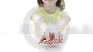 Close-up of smiling girl holding paper house