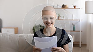 Close up smiling hairless woman reading good news in letter