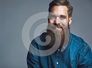 Close up on smiling male in denim shirt and beard