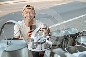 Close up of smiling male seller using phone camera when taking photo a kettles