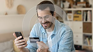 Close up smiling man wearing glasses making secure internet payment