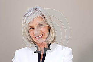 Close up smiling older business woman against wall