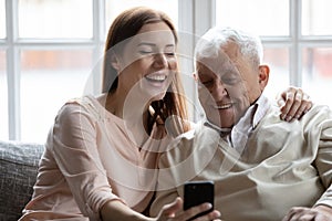 Close up smiling older man with grownup daughter making selfie