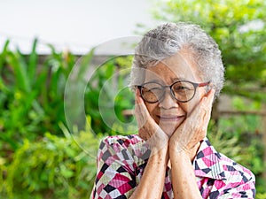 Close-up of smiling senior woman and hands touching on her face