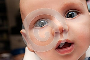 Close Up Smiling Surprised Happy Baby With Blue Eyes