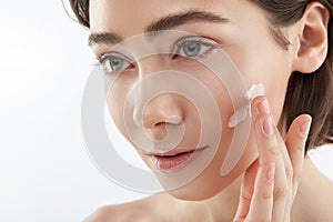 Close up smiling woman with cream on cheek