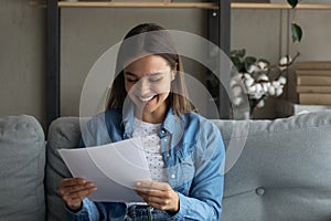 Close up smiling woman reading good news in letter