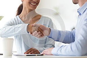 Close up smiling woman shaking hands with confident male partner.