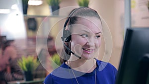 Close-up of smiling woman working in a call center. Customer service.