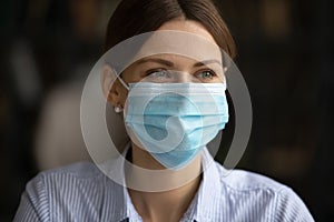 Smiling woman in facial mask protect from covid-19 photo