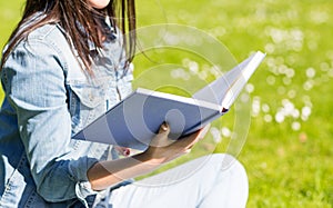 Close up of smiling young girl with book in park