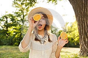 Close up of smiling young girl in summer hat spending time at the park