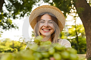 Close up of smiling young girl in summer hat spending time at the park