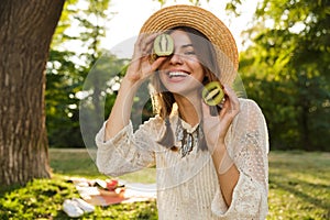 Close up of smiling young girl in summer hat spending time at the park,