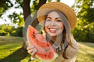 Close up of smiling young girl in summer hat spending time at the park