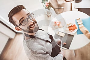 Close up. smiling young man slicing salami