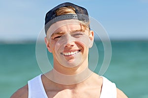 Close up of smiling young man on summer beach