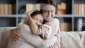 Close up smiling young woman hugging mature mother, expressing love