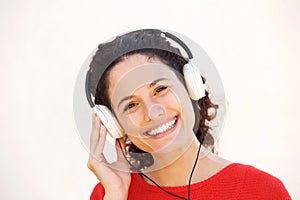 Close up smiling young woman listening to music with headphones